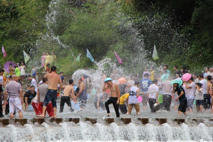 People celebrating Songkran splashing water at each other 